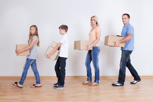 Professional movers handling desks and electronics during a local office move